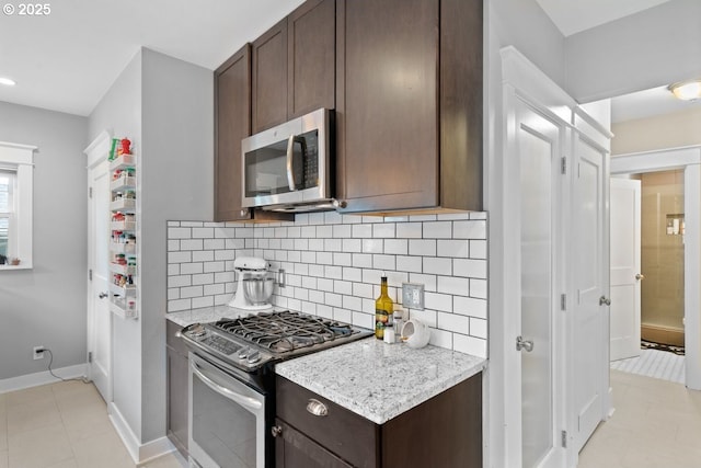 165 15th St, Salem, OR 97301 - kitchen with appliances with stainless steel finishes, dark brown cabinets, tasteful backsplash, light tile patterned floors, and recessed lighting