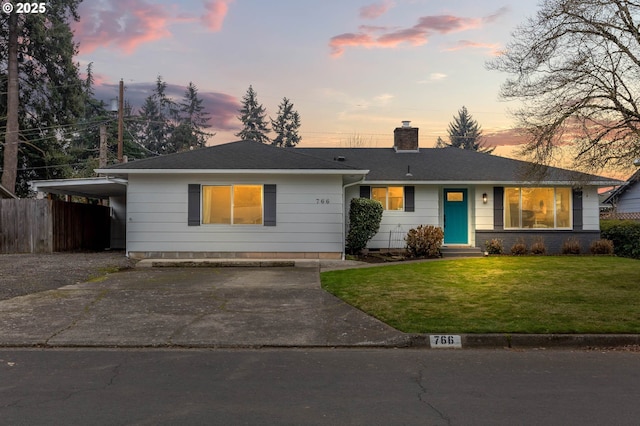 ranch-style home with a yard and a carport