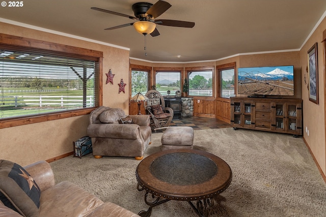 6419 NE Juniper Ridge Rd, Redmond, OR 97756 - carpeted living room with baseboards, ceiling fan, a wood stove, and crown molding
