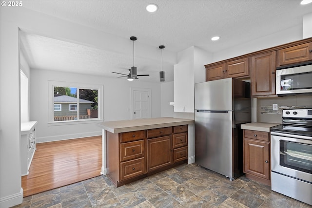 705 SE 5th St, Gresham, OR 97080 - kitchen with appliances with stainless steel finishes, a textured ceiling, light countertops, a peninsula, and ceiling fan