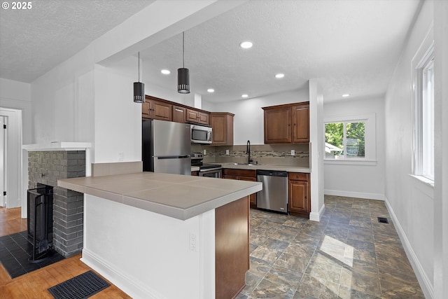 705 SE 5th St, Gresham, OR 97080 - kitchen with stainless steel appliances, a textured ceiling, a peninsula, light countertops, and recessed lighting