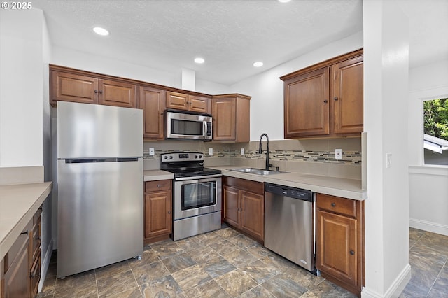705 SE 5th St, Gresham, OR 97080 - kitchen featuring appliances with stainless steel finishes, recessed lighting, dark stone finish flooring, light countertops, and decorative backsplash