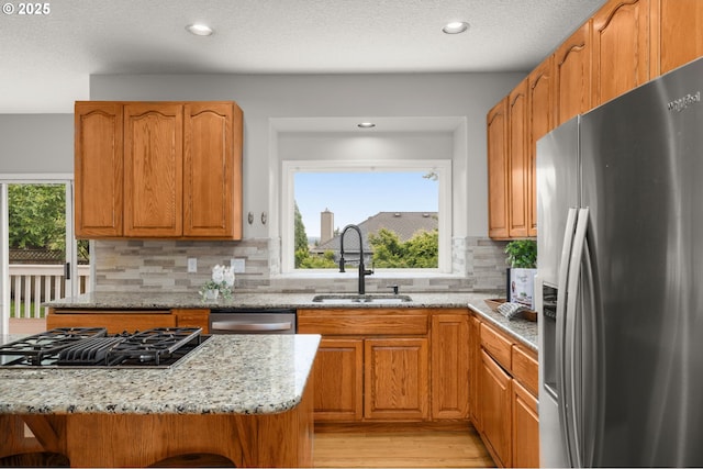 4025 Horton Rd, West Linn, OR 97068 - kitchen with stainless steel appliances, light stone countertops, light wood-style flooring, decorative backsplash, and recessed lighting