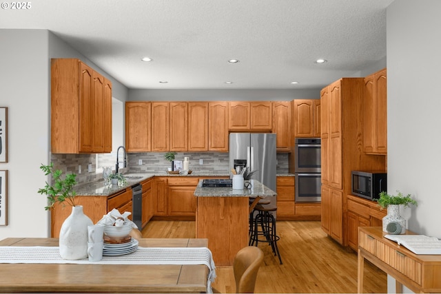 4025 Horton Rd, West Linn, OR 97068 - kitchen with stainless steel appliances, a center island, tasteful backsplash, light wood-type flooring, and recessed lighting