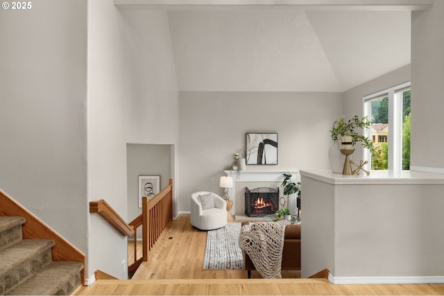 4025 Horton Rd, West Linn, OR 97068 - living area with lofted ceiling, wood finished floors, a warm lit fireplace, and stairway
