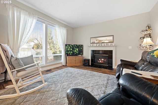 living room featuring hardwood / wood-style flooring and a tile fireplace