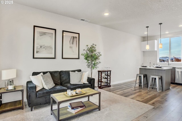 1669 SE Sherrett St, Portland, OR 97202 - living room with light wood-style flooring, recessed lighting, and bar with sink
