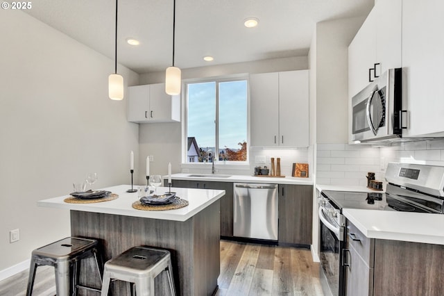 1669 SE Sherrett St, Portland, OR 97202 - kitchen featuring stainless steel appliances, light wood-style flooring, light countertops, and recessed lighting