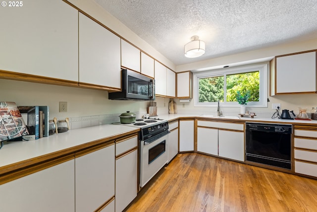 4300 Botticelli St, Lake Oswego, OR 97035 - kitchen with white electric range, black dishwasher, stainless steel microwave, light countertops, and white cabinetry