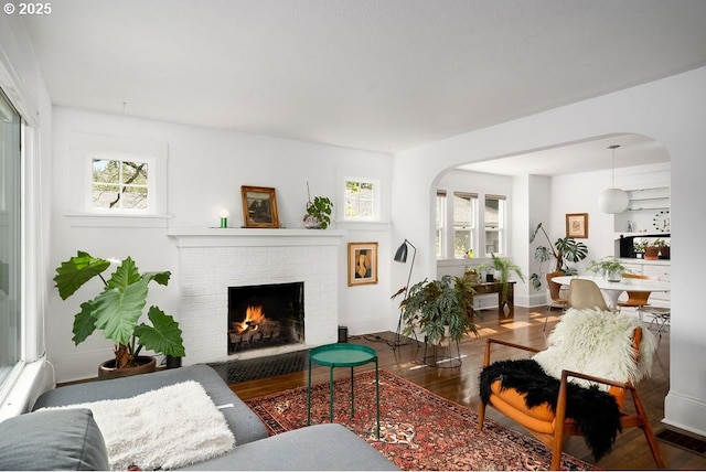 4541 NE 36th Ave, Portland, OR 97211 - living room with arched walkways, wood finished floors, a fireplace, and plenty of natural light