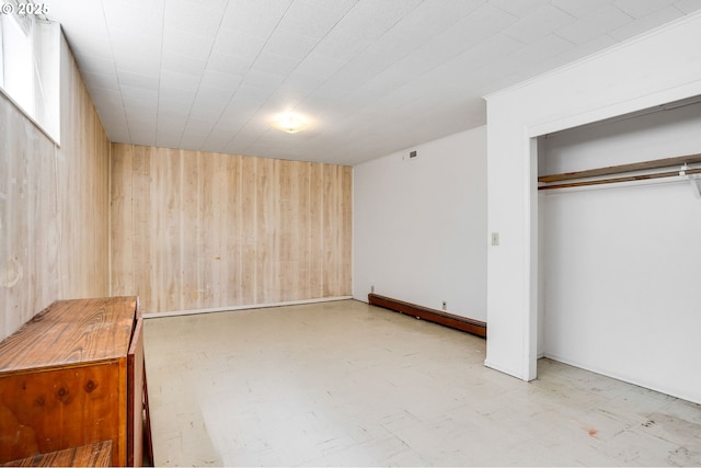 2210 Winter St SE, Salem, OR 97302 - unfurnished bedroom featuring wooden walls, a baseboard radiator, a closet, and tile patterned floors