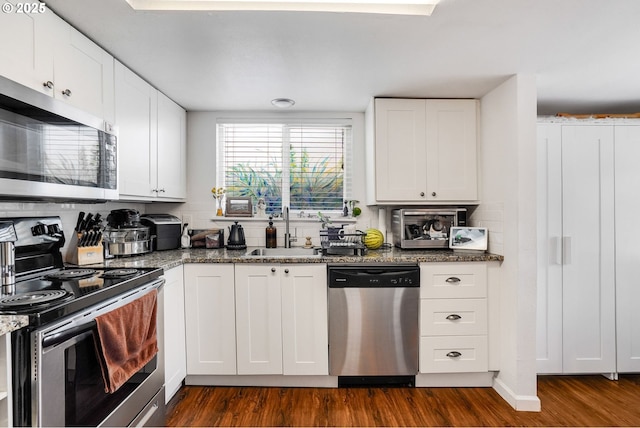 2210 Winter St SE, Salem, OR 97302 - kitchen with stainless steel appliances, dark wood finished floors, white cabinetry, and dark stone countertops