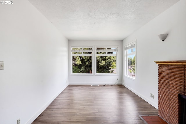 2210 Winter St SE, Salem, OR 97302 - unfurnished living room featuring a textured ceiling, wood finished floors, and a fireplace