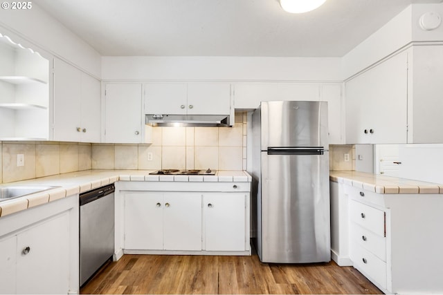 2210 Winter St SE, Salem, OR 97302 - kitchen with appliances with stainless steel finishes, open shelves, under cabinet range hood, white cabinetry, and backsplash