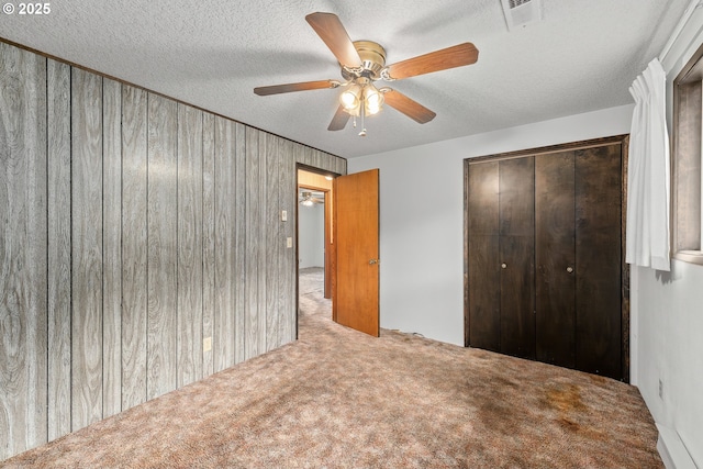 1223 Sable Dr, Roseburg, OR 97470 - unfurnished bedroom with carpet flooring, a closet, a textured ceiling, wood walls, and ceiling fan