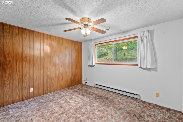 1223 Sable Dr, Roseburg, OR 97470 - carpeted empty room featuring a baseboard radiator, ceiling fan, a textured ceiling, and wooden walls