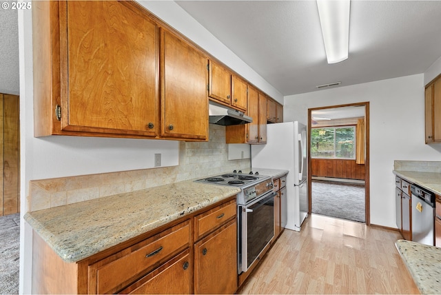 1223 Sable Dr, Roseburg, OR 97470 - kitchen featuring appliances with stainless steel finishes, under cabinet range hood, light wood-style floors, brown cabinets, and baseboard heating