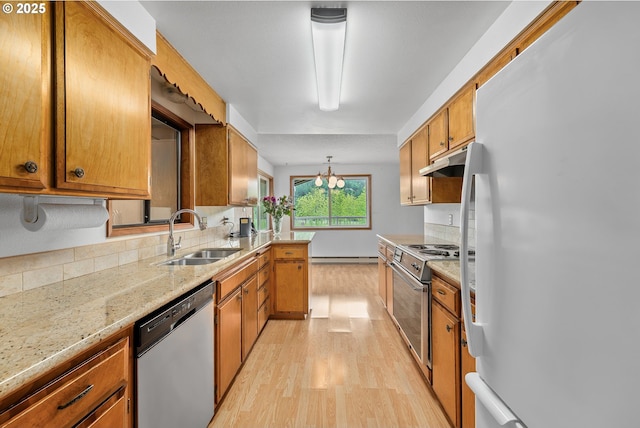1223 Sable Dr, Roseburg, OR 97470 - kitchen with stainless steel appliances, a sink, under cabinet range hood, light wood-style flooring, and tasteful backsplash