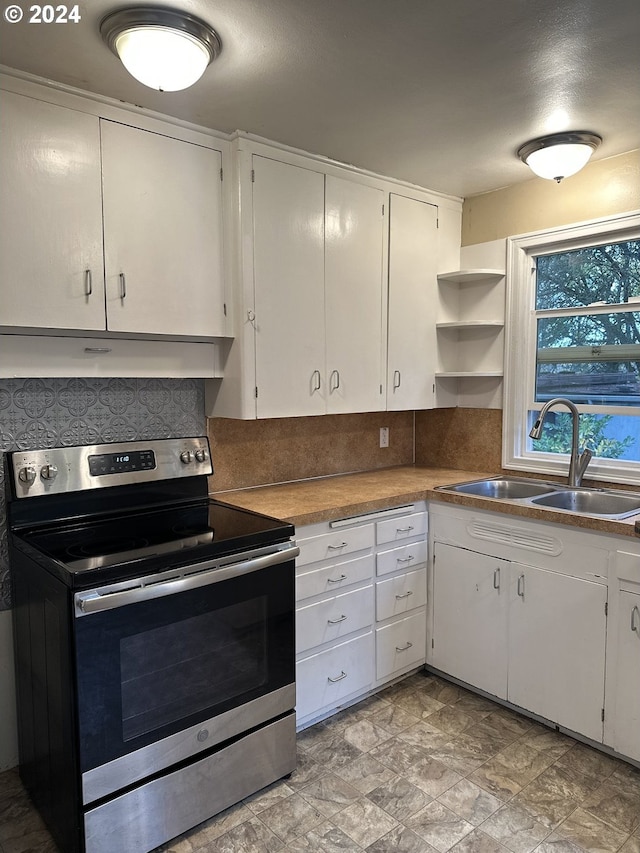 kitchen featuring white cabinetry, stainless steel electric range oven, sink, and tasteful backsplash