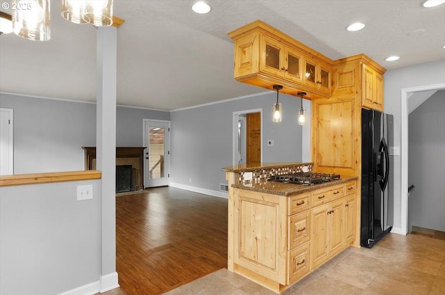 8835 NE Broadway, Portland, OR 97220 - kitchen with black fridge with ice dispenser, glass insert cabinets, baseboards, dark stone counters, and ornamental molding
