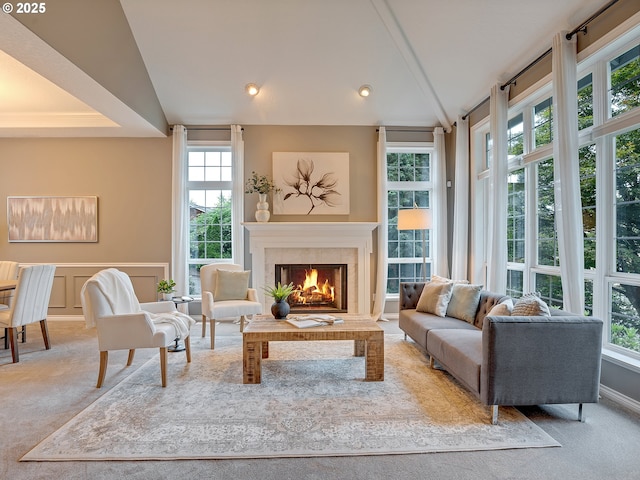 1354 Skye Pkwy, West Linn, OR 97068 - carpeted living area featuring a warm lit fireplace, lofted ceiling, a decorative wall, and a wainscoted wall