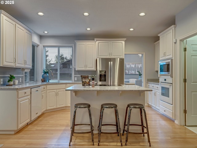 1354 Skye Pkwy, West Linn, OR 97068 - kitchen featuring stainless steel appliances, light wood-type flooring, a center island, recessed lighting, and a kitchen bar