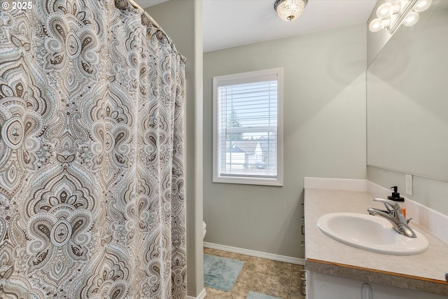 full bathroom featuring toilet, vanity, and baseboards