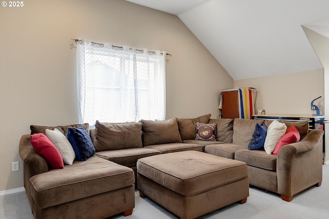 living room with vaulted ceiling, light carpet, and baseboards