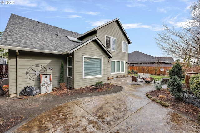 back of house featuring a patio area, fence, an outdoor living space, and roof with shingles