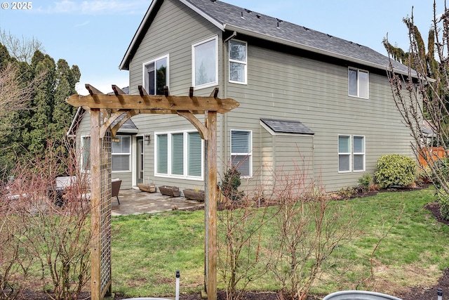 back of property featuring a patio area, a pergola, and a yard