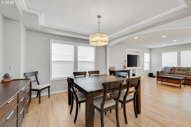 dining area with light wood-style floors, baseboards, a raised ceiling, and recessed lighting