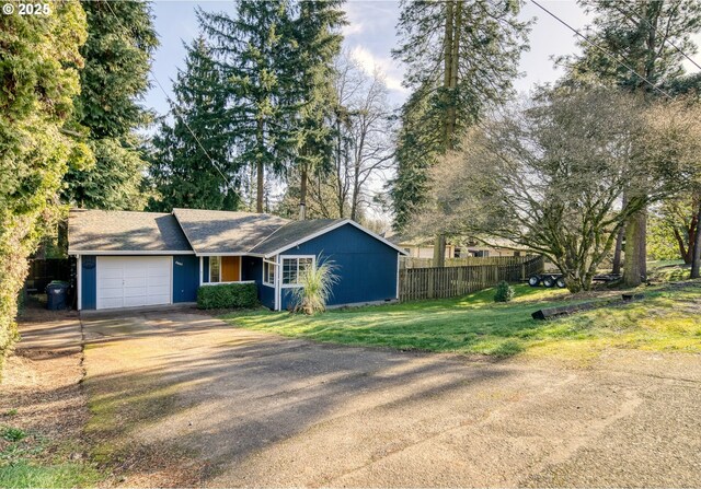 ranch-style home featuring a garage, driveway, a front lawn, and fence