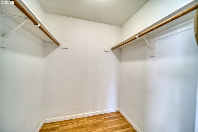 walk in closet with light wood-style floors