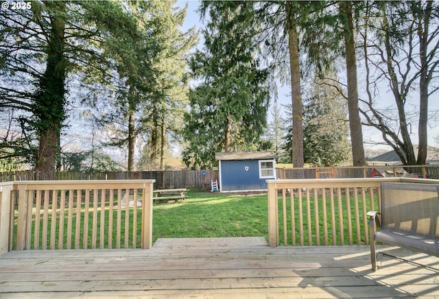 deck with an outbuilding, a fenced backyard, a lawn, and a shed