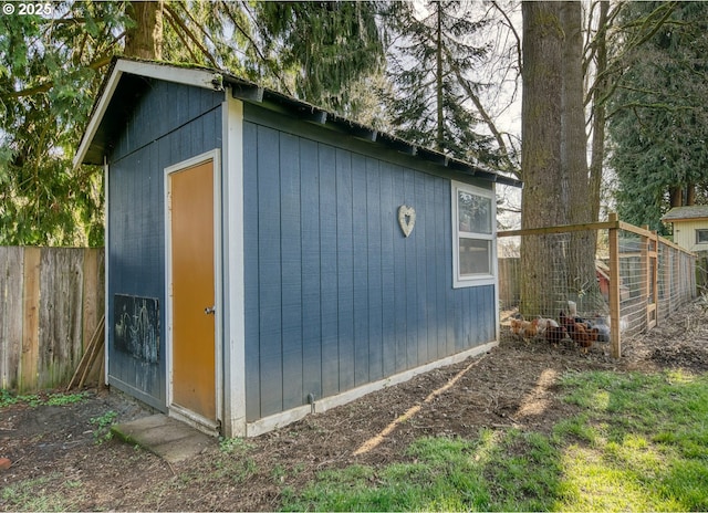 view of outdoor structure featuring an outbuilding and fence