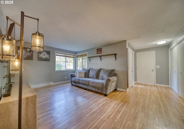 living room featuring baseboards, a baseboard radiator, and light wood-style floors