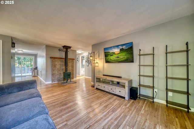 living area featuring a wood stove, baseboards, and wood finished floors