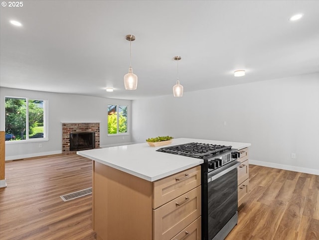 9995 SW Siuslaw Ln, Tualatin, OR 97062 - kitchen with stainless steel gas range oven, light wood-style flooring, light countertops, plenty of natural light, and recessed lighting