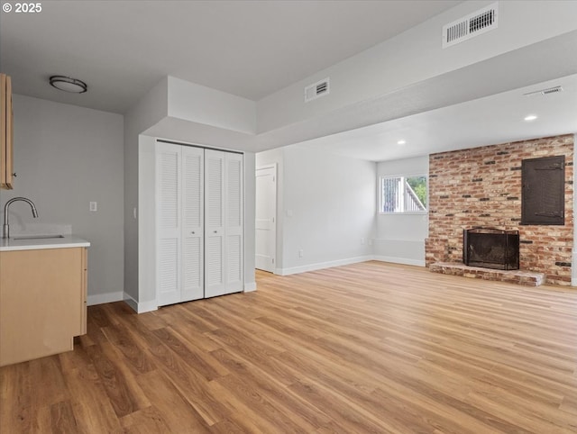 9995 SW Siuslaw Ln, Tualatin, OR 97062 - unfurnished living room with light wood-style flooring and a fireplace