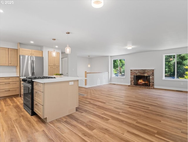 9995 SW Siuslaw Ln, Tualatin, OR 97062 - kitchen featuring black gas range, freestanding refrigerator, light brown cabinetry, light countertops, and light wood-type flooring