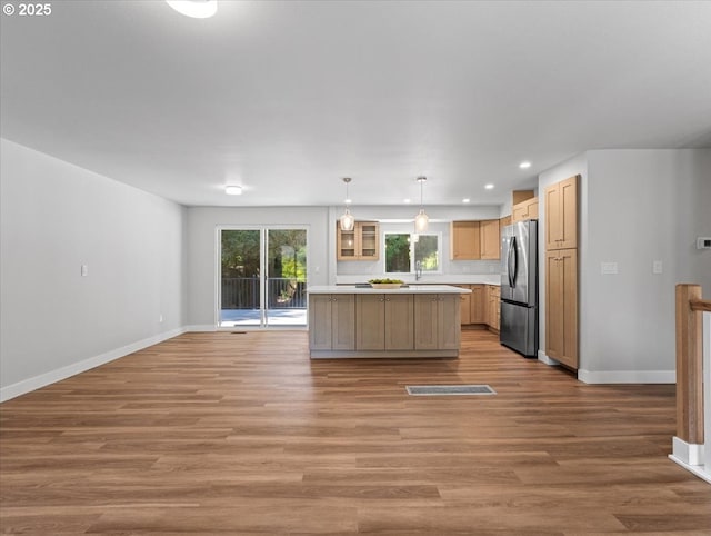 9995 SW Siuslaw Ln, Tualatin, OR 97062 - kitchen with freestanding refrigerator, light countertops, a kitchen island, wood finished floors, and recessed lighting