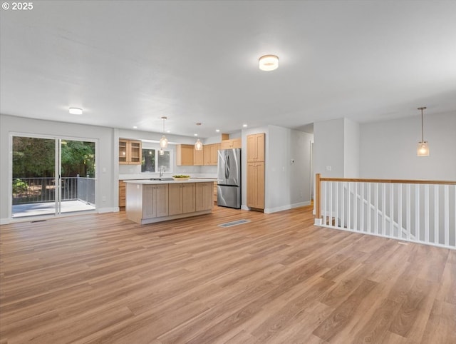 9995 SW Siuslaw Ln, Tualatin, OR 97062 - kitchen with freestanding refrigerator, open floor plan, light wood finished floors, light countertops, and recessed lighting