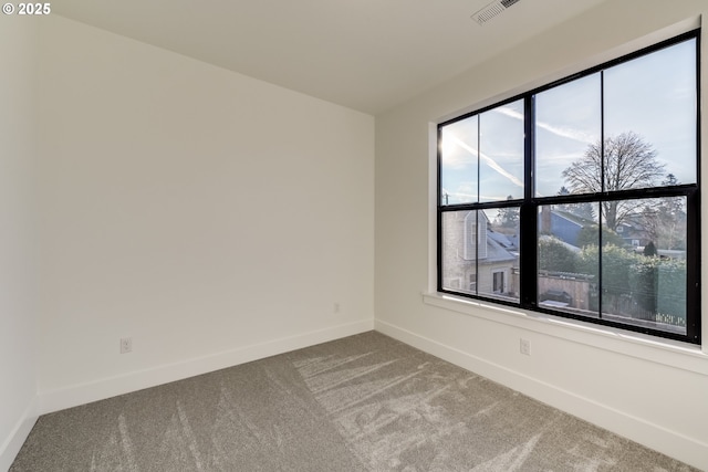 carpeted empty room featuring visible vents and baseboards