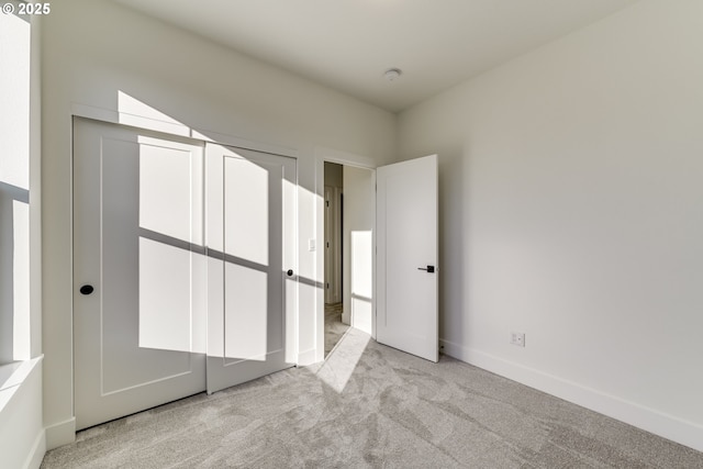 unfurnished bedroom with light carpet and baseboards