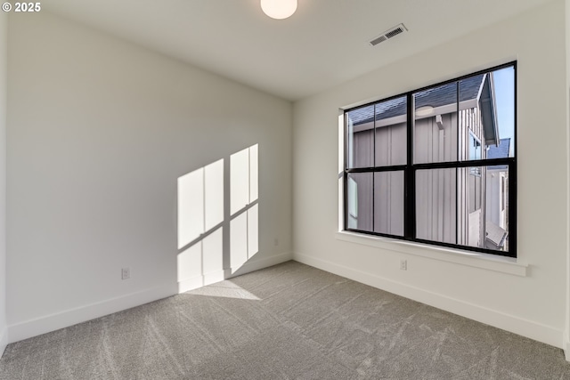 spare room with light carpet, visible vents, and baseboards