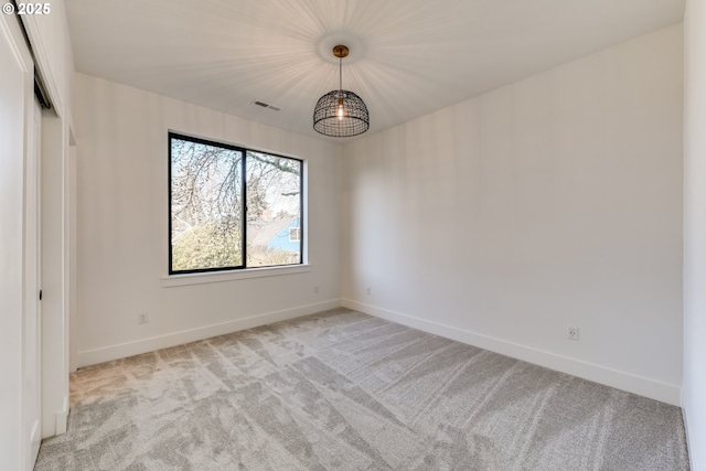 empty room featuring light carpet, visible vents, and baseboards