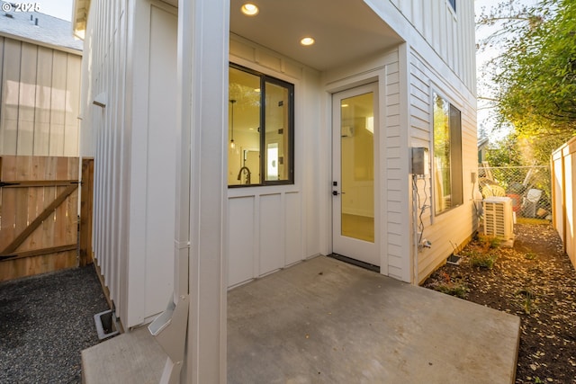 doorway to property featuring a patio area, fence, and board and batten siding