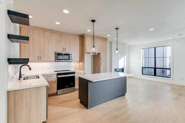 kitchen featuring hanging light fixtures, a kitchen island, appliances with stainless steel finishes, and light brown cabinetry