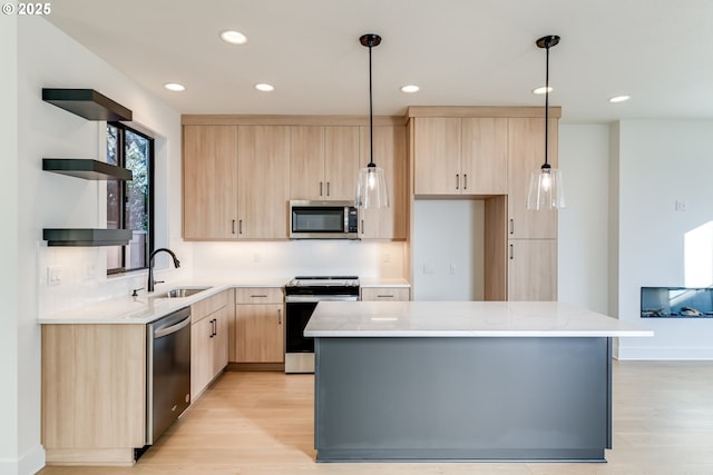 kitchen with a sink, stainless steel appliances, hanging light fixtures, and light brown cabinets