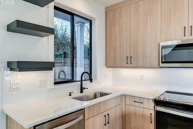 kitchen with appliances with stainless steel finishes, open shelves, a sink, and light brown cabinetry